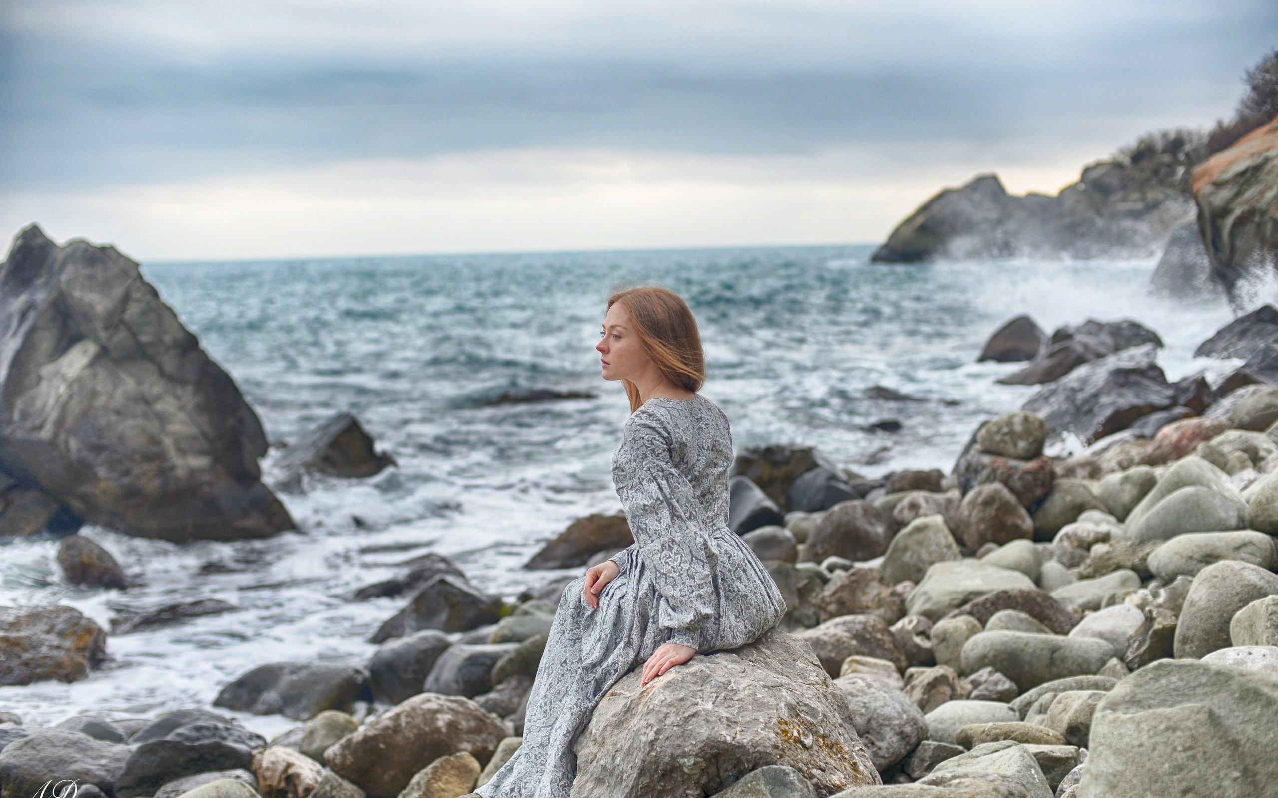 Девушка сидит на Камне у моря