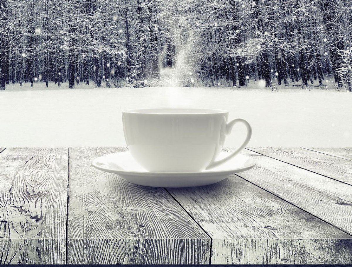 Чашка кофе на фоне зимнего пейзажа.